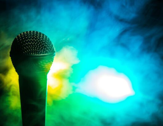 Microphone in front of blue & yellow-lit smoke